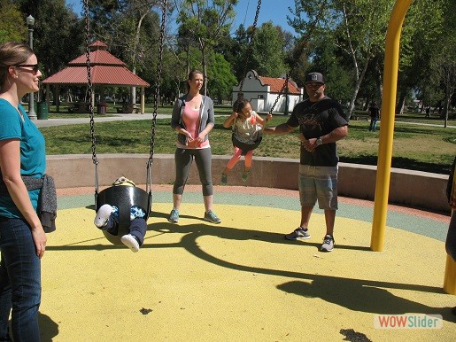 children and their parents playing on the swingset at fairmount park